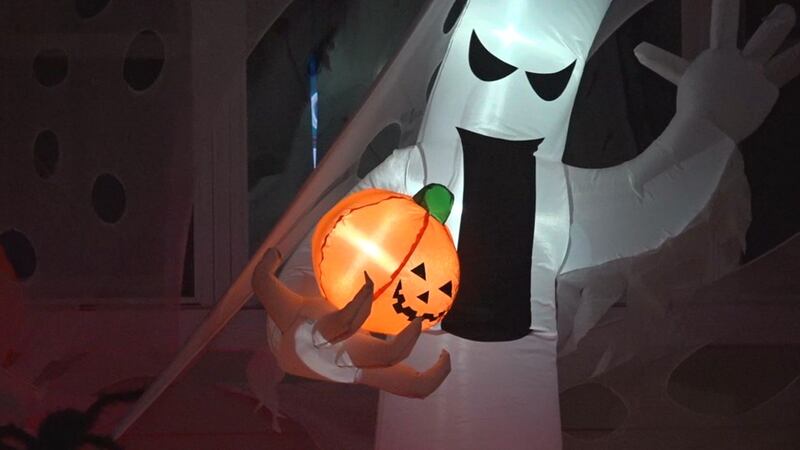 An inflatable ghost outside one Rapid City home is part of a friendly competition among...
