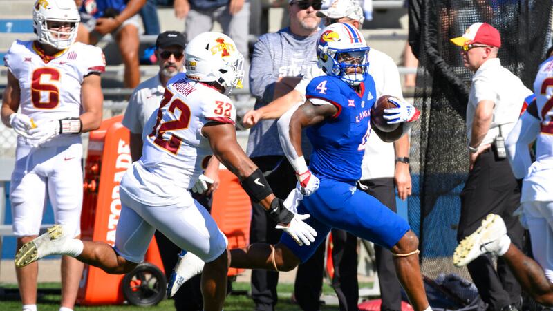Kansas running back Devin Neal (4) tries to outrun Iowa State linebacker Gerry Vaughn (32)...