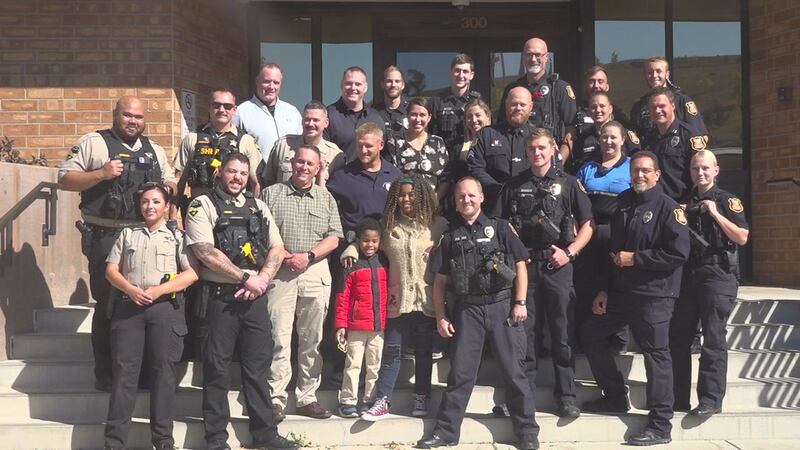 Rosalyn Baldwin and her brother pose with the Rapid City Police Department and Pennington...