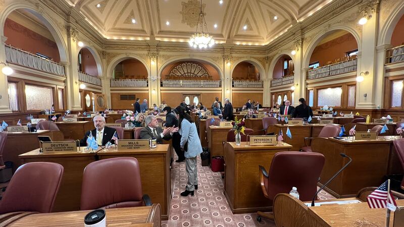South Dakota state lawmakers converse on the House floor following contentious debate on a...