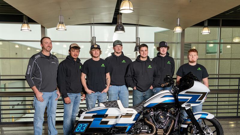 Students of Mitchell Technical College pose proudly next to their rebuilt motorcycle.